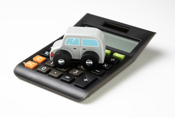 Car leasing, rental or insurance and maintenance calculation concept, cute wooden small toy car parking on black calculator on white background, down payment, installment for auto market