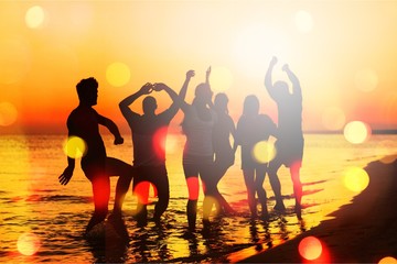 Fototapeta premium Friends jumping on beach at seaside at