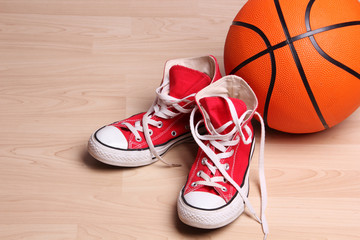 Basketball and red sneakers on the floor