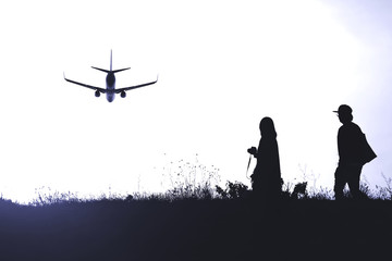 Fototapeta na wymiar silhouette of two people on the background of a flying plane