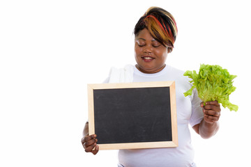 Studio shot of happy fat black African woman smiling while holdi