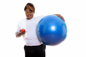 Studio shot of happy fat black African woman smiling while holdi