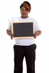 Studio shot of fat black African woman standing while holding bl