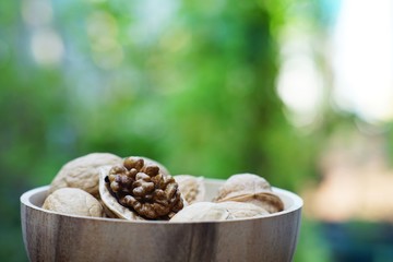 Group of walnut in wooden bowl on wood background, copy space, super food concept