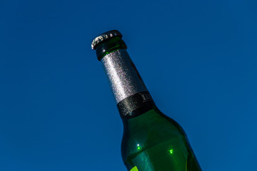 Bierflasche vor blauem Himmel