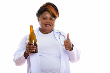 Studio shot of happy fat black African woman doctor smiling and 