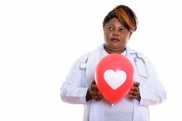 Studio shot of fat black African woman doctor thinking while hol