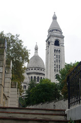Fototapeta na wymiar The Basilica of the Sacré Coeur in Montmartre in Paris with trees