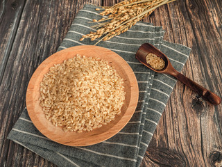 brown rice in a wooden bowl with spoon
