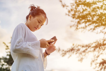 Concerned looking Asian teenage girl looking at her phone.