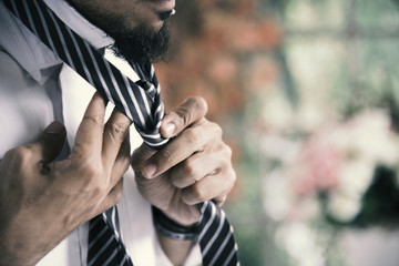 Handsome groomsman wear tie preparing to be best man for groom in a wedding day. Formal suit. Wedding concept