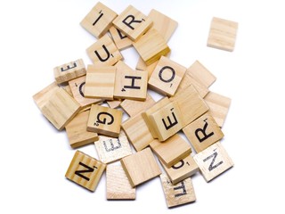 The wooden alphabets with a black  letters on the brown wood, this image isolated on white background