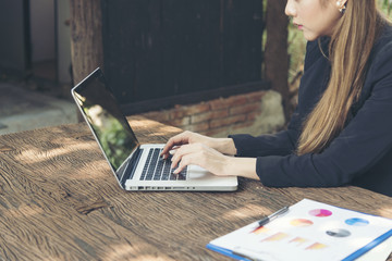 Beautiful businesswoman using laptop working outdoor and reading annual report document. holding smart tablet. technology concept.