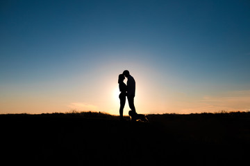 Fototapeta premium Romantic couple hug at sunset on background.