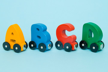 Letters A, B, C, D of a train alphabet with locomotive. Bright colors of red yellow green and blue on a white background. Early childhood education, learning to read and kids game concept.
