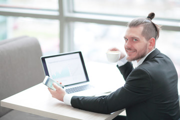 successful businessman is drinking coffee,sitting at his Desk