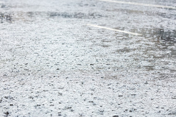 rain rippling in big water puddle on asphalt city road