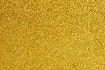 Gold paint on rough cement wall texture background