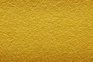 Gold paint on rough cement wall texture background