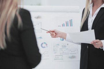 close up. business woman showing a pen on a flipchart ,with financial data