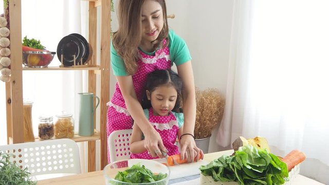 Beautiful asian mother and daughter cooking food in kitchen.