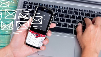 Male hands with phone on laptop on