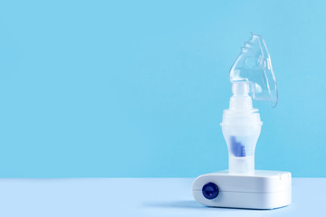 Nebulizer on a blue background. Inhalation treatment