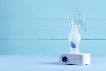 Nebulizer on a blue background. Inhalation treatment. Copy space