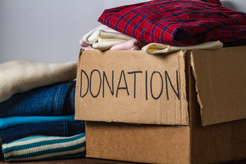 Donation concept. Donation box with donation clothes on a table. Charity. Help for people in need