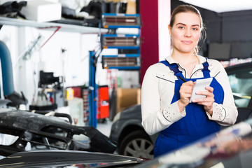 Girl mechanic taking notes on notebook