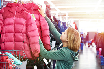 Woman chooses winter jacket in store