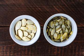 Pumpkin seeds in small saucers on a wooden background