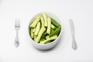 Diet concept: A plate with cucumbers with a fork and knife on each side of it.
