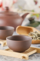brown ceramic teapot with cups on special wooden coasters is prepared for a traditional Asian tea ceremony