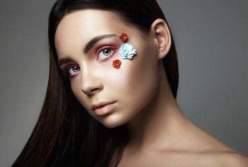 Beautiful Girl with Flowers on face. beauty Make-up