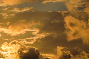 Dramatic sunset sky with orange colored clouds.