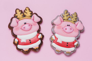two honey cakes in the shape of pink piglets with golden horns on a pink background, minimal concept of christmas, finances and savings