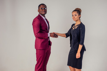 female businesswoman and his Aro-American partner shaking hands in the studio on a white background