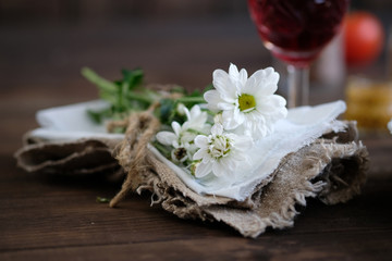 chamomiles in napkin on old rustic wooden table