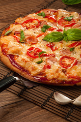 Hot pizza slice with melting cheese on a rustic wooden table