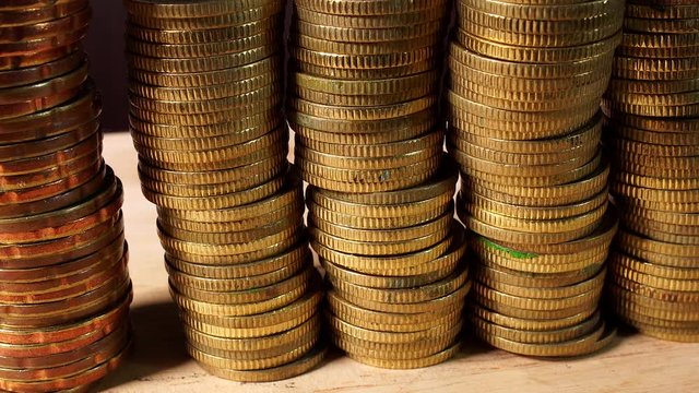Stacks of Gold Coins isolated indoors on wooden table