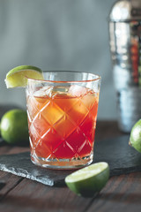 The alcoholic Surfer on Acid cocktail in a old-fashioned glass with a lime wedge.