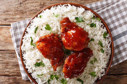fried chicken thighs with catalina sauce served with rice on a plate. horizontal top view from above