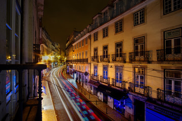 Fototapeta na wymiar Night Lights Motion Blur over Cobblestone Street of Lisbon Portugal