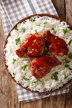 fried chicken thighs with catalina sauce served with rice on a plate. Vertical top view from above
