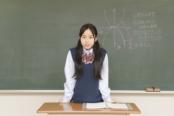 黒板に数式を書き込む女子高生