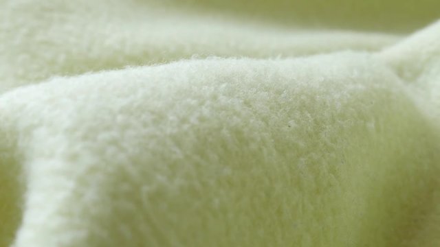 Shallow DOF fibers of green polar fleece blanket 4K video
