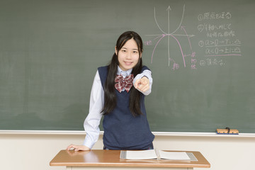 黒板に数式を書く女子高校生