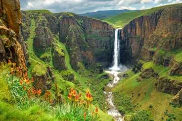 Poster Maletsunyane Falls in Lesotho Africa. Most beautiful waterfall in the world. Green scenic landscape of amazing water fall dropping into a river inside canyons. Panoramic views over the great falls. © mbrand85