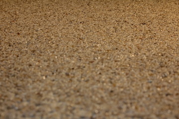 Fototapeta na wymiar красивый песочный фон из мелких бежевых камней, крупным планом 
